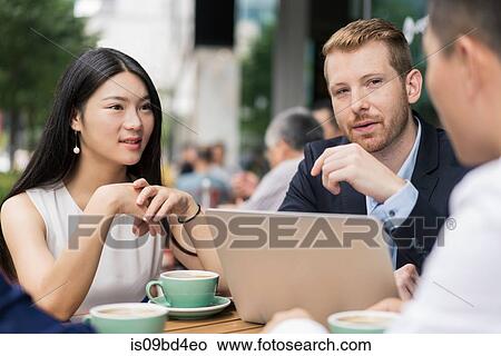 Group of businesspeople, having meeting at cafe, using laptop, outdoors View Large Photo Image Picture - Group of businesspeople, having meeting at cafe, using laptop, outdoors. Fotosearch