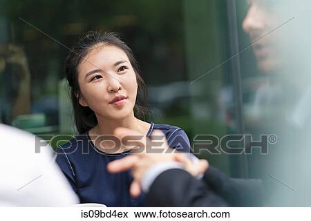 Stock Photo - Group of businesspeople, having meeting at cafe, outdoors. Fotosearch