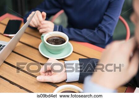 Group of businesspeople, having meeting at cafe, outdoors, mid section View Large Photo Image Stock Photograph - Group of businesspeople, having meeting at cafe, outdoors, mid section. Fotosearch