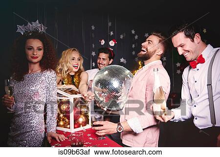 Stock Image - Group of friends at party, laughing, fooling around. Fotosearch
