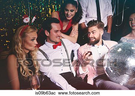 Group of friends sitting together at party, man holding disco ball in lap View Large Photo Image Stock Image - Group of friends sitting together at party, man holding disco ball in lap. Fotosearch
