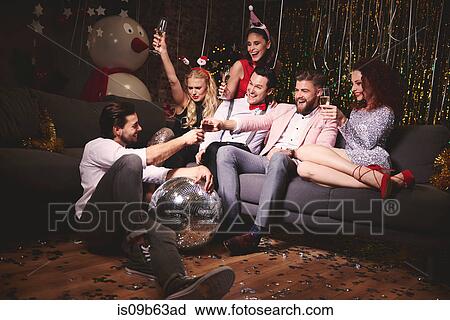 Group of friends sitting together at party, holding drinks, making a toast View Large Photo Image Stock Image - Group of friends sitting together at party, holding drinks, making a toast. Fotosearch