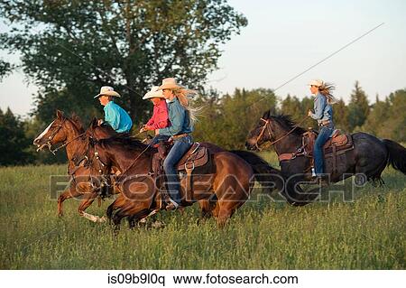 Group of people riding horses in field View Large Photo Image Stock Photography - Group of people riding horses in field. Fotosearch