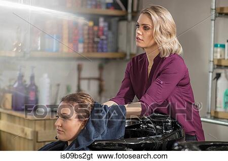 Hairdresser drying customer's hair in salon View Large Photo Image Stock Photograph - Hairdresser drying customer's hair in salon. Fotosearch