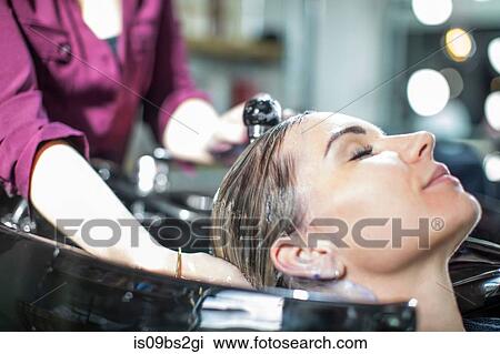 Hairdresser rinsing customer's hair in salon View Large Photo Image Stock Image - Hairdresser rinsing customer's hair in salon. Fotosearch