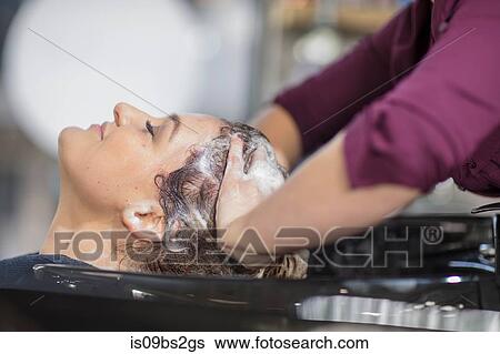 Stock Photograph - Hairdresser shampooing customer's hair in salon. Fotosearch
