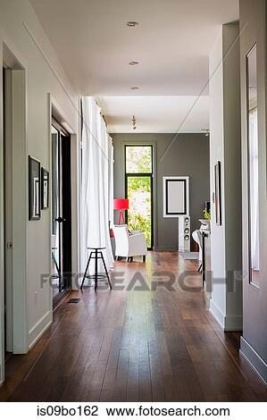 Hallway with qumaru wood floorboards leading to living room with white leather armchair, luxurious modern cube style house interior View Large Photo Image Stock Image - Hallway with qumaru wood floorboards leading to living room with white leather armchair, luxurious modern cube style house interior. Fotosearch