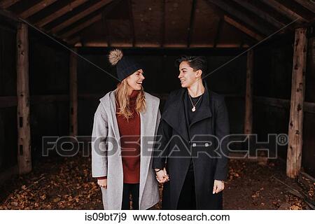 Happy couple standing side by side holding hands View Large Photo Image Stock Photo - Happy couple standing side by side holding hands. Fotosearch