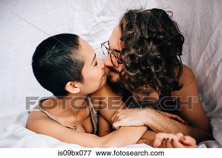 Happy couple under covers in bed View Large Photo Image Stock Photo - Happy couple under covers in bed. Fotosearch