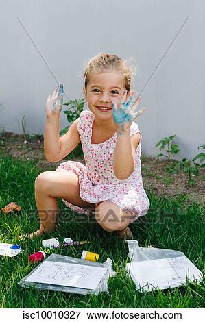 Happy little girl playing with paint in garden View Large Photo Image Stock Photo - Happy little girl playing with paint in garden. Fotosearch