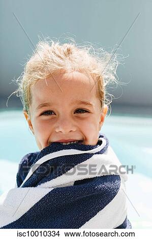 Picture - Happy little girl wrapped in towel by swimming pool. Fotosearch