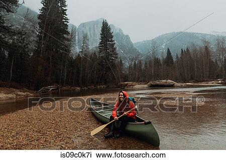 Happy young female canoeist sitting on canoe in river, Yosemite Village, California, USA View Large Photo Image Stock Image - Happy young female canoeist sitting on canoe in river, Yosemite Village, California, USA. Fotosearch