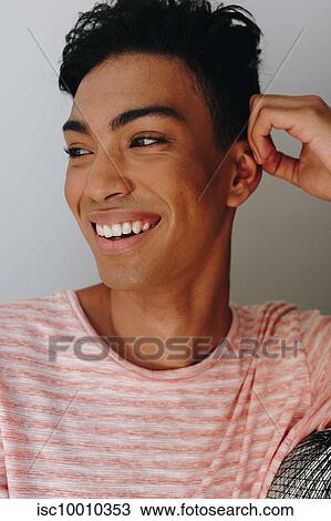Happy young man with hand on ear looking away, head and shoulders View Large Photo Image Stock Image - Happy young man with hand on ear looking away, head and shoulders. Fotosearch