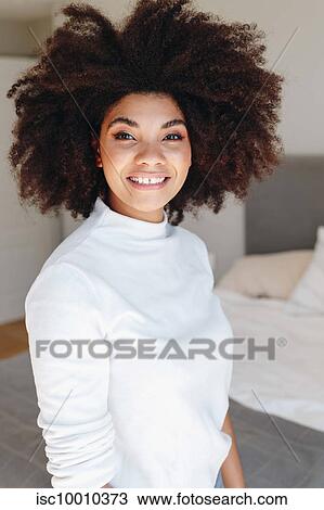 Happy young woman with afro hairstyle in bedroom, waist up portrait View Large Photo Image Stock Image - Happy young woman with afro hairstyle in bedroom, waist up portrait. Fotosearch