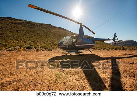 Helicopter and pilot in sunlit rural landscape, Cape Town, Western Cape, South Africa View Large Photo Image Stock Image - Helicopter and pilot in sunlit rural landscape, Cape Town, Western Cape, South Africa. Fotosearch