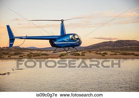 Stock Image - Helicopter flying above watering hole, Cape Town, Western Cape, South Africa. Fotosearch