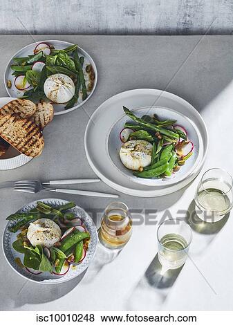 High key still life with glasses of white wine and plates of burrata spring salad on white table, overhead view View Large Photo Image Stock Photo - High key still life with glasses of white wine and plates of burrata spring salad on white table, overhead view. Fotosearch