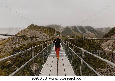 Hiker crossing suspension bridge, Wanaka, Taranaki, New Zealand View Large Photo Image Stock Photograph - Hiker crossing suspension bridge, Wanaka, Taranaki, New Zealand. Fotosearch
