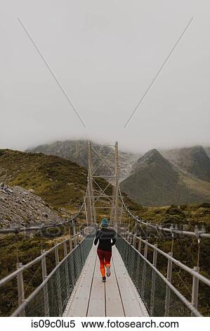 Hiker crossing suspension bridge, Wanaka, Taranaki, New Zealand View Large Photo Image Stock Photography - Hiker crossing suspension bridge, Wanaka, Taranaki, New Zealand. Fotosearch