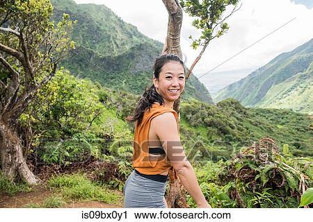 Stock Image - Hiker enjoying rainforest, Iao Valley, Maui, Hawaii. Fotosearch