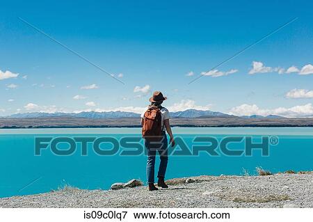 Stock Photo - Hiker enjoying sea view, Wanaka, Taranaki, New Zealand. Fotosearch