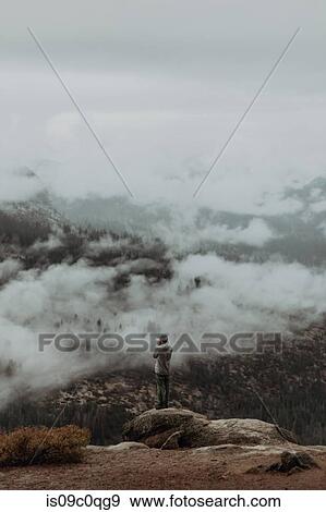 Hiker enjoying view of fog covering valley, Yosemite National Park, California, United States View Large Photo Image Stock Photo - Hiker enjoying view of fog covering valley, Yosemite National Park, California, United States. Fotosearch