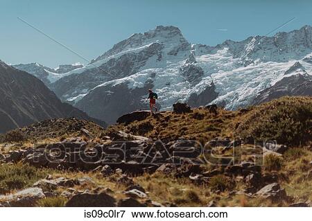 Stock Photo - Hiker exploring wilderness, Wanaka, Taranaki, New Zealand. Fotosearch