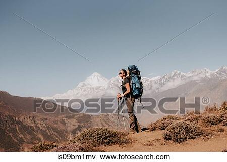 Stock Photo - Hiker on peak, Annapurna Circuit, the Himalayas, Dhaulagiri and Tukuche mountains in background, Muktinath, Nepal. Fotosearch