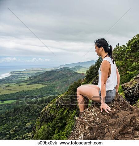 Hiker on rock on top of mountain, Sleeping Giant Trail, Kauai, Hawaii View Large Photo Image Stock Image - Hiker on rock on top of mountain, Sleeping Giant Trail, Kauai, Hawaii. Fotosearch