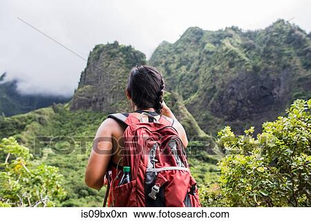Picture - Hiker stopping to enjoy rainforest, Iao Valley, Maui, Hawaii. Fotosearch
