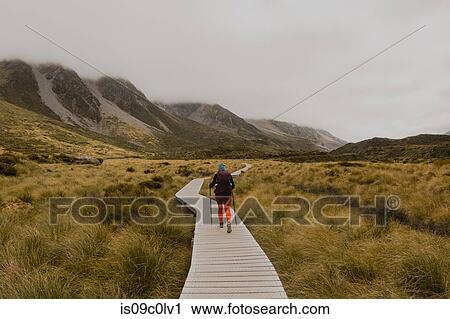 Stock Image - Hiker walking on trail path, Wanaka, Taranaki, New Zealand. Fotosearch