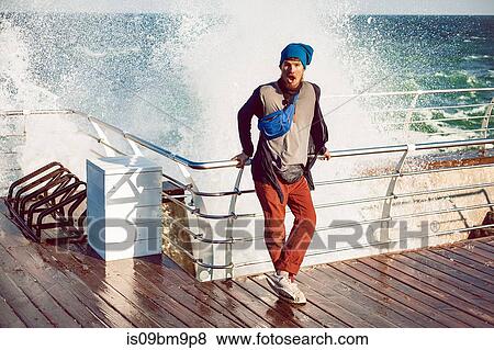 Hipster against railing, sea splash in background View Large Photo Image Stock Photo - Hipster against railing, sea splash in background. Fotosearch