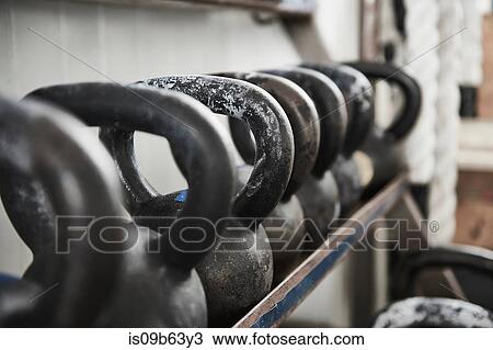 Stock Image - Kettlebells on rack. Fotosearch