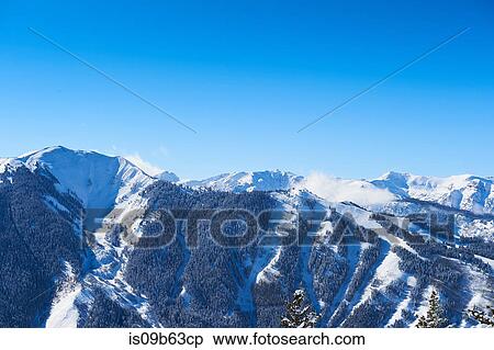Landscape view of snow covered mountains and blue sky, Aspen, Colorado, USA View Large Photo Image Stock Photography - Landscape view of snow covered mountains and blue sky, Aspen, Colorado, USA. Fotosearch
