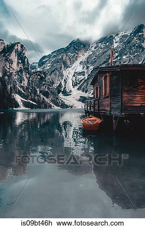 Landscape with lakeside log cabin and snow capped mountains, Dolomites, Italy View Large Photo Image Stock Image - Landscape with lakeside log cabin and snow capped mountains, Dolomites, Italy. Fotosearch