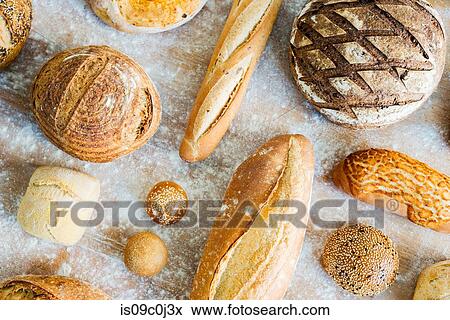 Stock Photo - Large variety of wholemeal and white bread rolls and loaves, overhead view. Fotosearch
