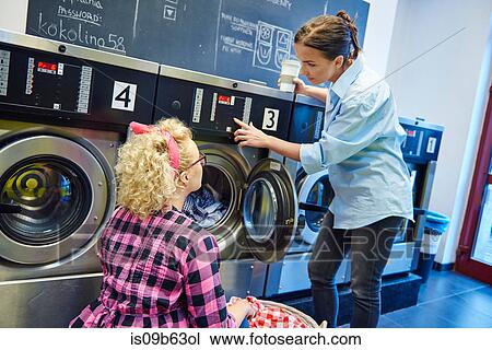 Laundrette business owner showing woman washing machine control panel View Large Photo Image Stock Image - Laundrette business owner showing woman washing machine control panel. Fotosearch