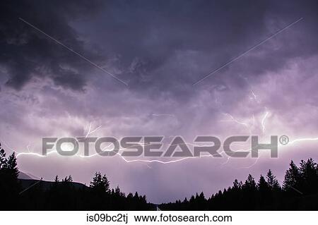Stock Image - Lightning in sky over Canadian Rocky Mountains, Kootenay Region, Fernie, British Columbia, Canada. Fotosearch