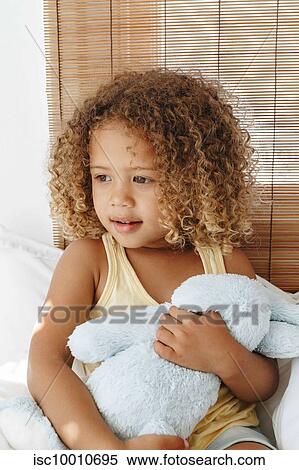 Little girl cradling soft toy, daydreaming in bed View Large Photo Image Stock Photography - Little girl cradling soft toy, daydreaming in bed. Fotosearch