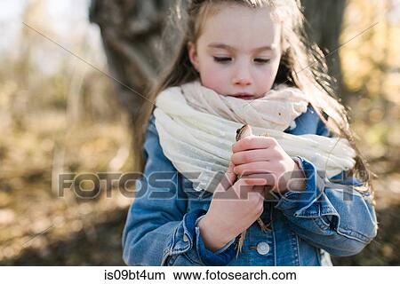 Picture - Little girl holding frog in forest. Fotosearch