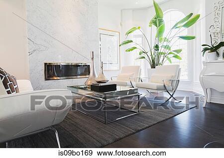 Living room with white leather and chrome sofa and matching armchairs facing coffee table inside luxury residential home View Large Photo Image Stock Photo - Living room with white leather and chrome sofa and matching armchairs facing coffee table inside luxury residential home. Fotosearch