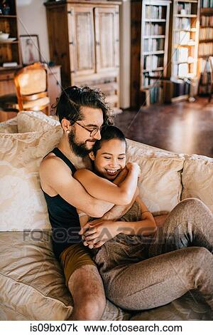 Stock Image - Loving couple relaxing on sofa. Fotosearch