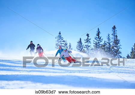 Stock Photo - Male and female skiers skiing down snow covered ski slope, Aspen, Colorado, USA. Fotosearch