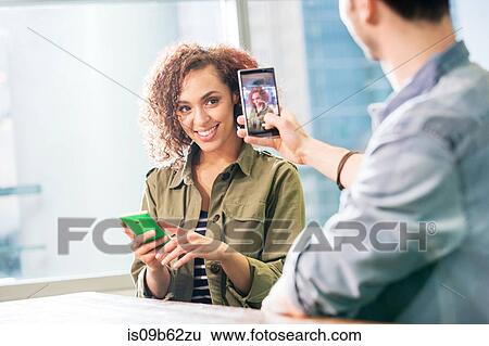 Male digital designer photographing colleague in office View Large Photo Image Stock Photograph - Male digital designer photographing colleague in office. Fotosearch