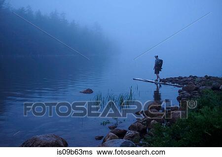 Stock Photograph - Male hiker by misty river, Acadia, Maine, USA. Fotosearch