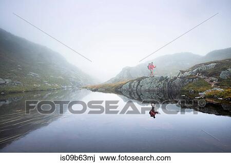 Male hiker hiking along foggy riverbank, Gros Morne National Park, Newfoundland, Canada View Large Photo Image Stock Image - Male hiker hiking along foggy riverbank, Gros Morne National Park, Newfoundland, Canada. Fotosearch