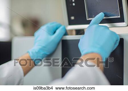 Picture - Male worker in thread factory, using touch screen, close-up. Fotosearch