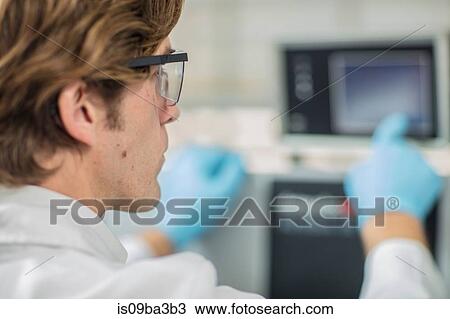 Stock Image - Male worker in thread factory, using touch screen. Fotosearch