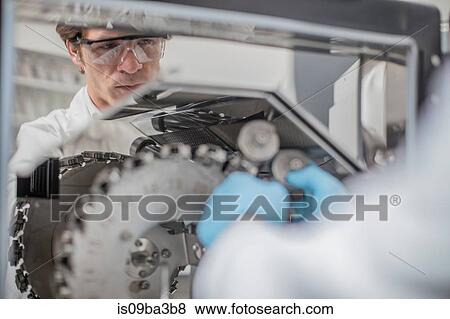 Stock Photo - Male worker in thread factory, using chemical oven. Fotosearch