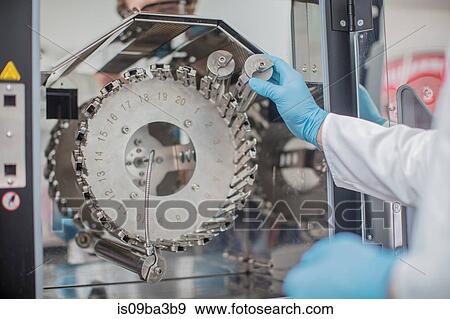 Stock Photo - Male worker in thread factory, using chemical oven. Fotosearch